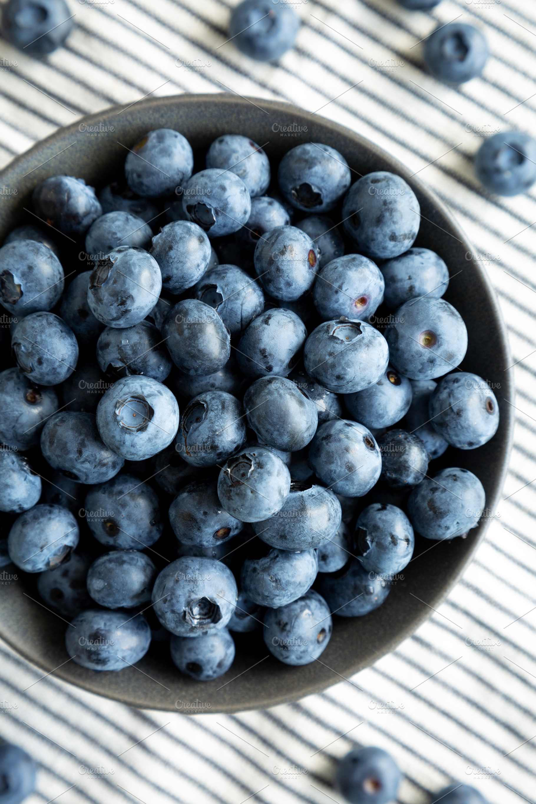 Raw Organic Blueberries in a Bowl, top view. Overhead, from abov, a Food & Drink Photo by LiudmylaChuhunova