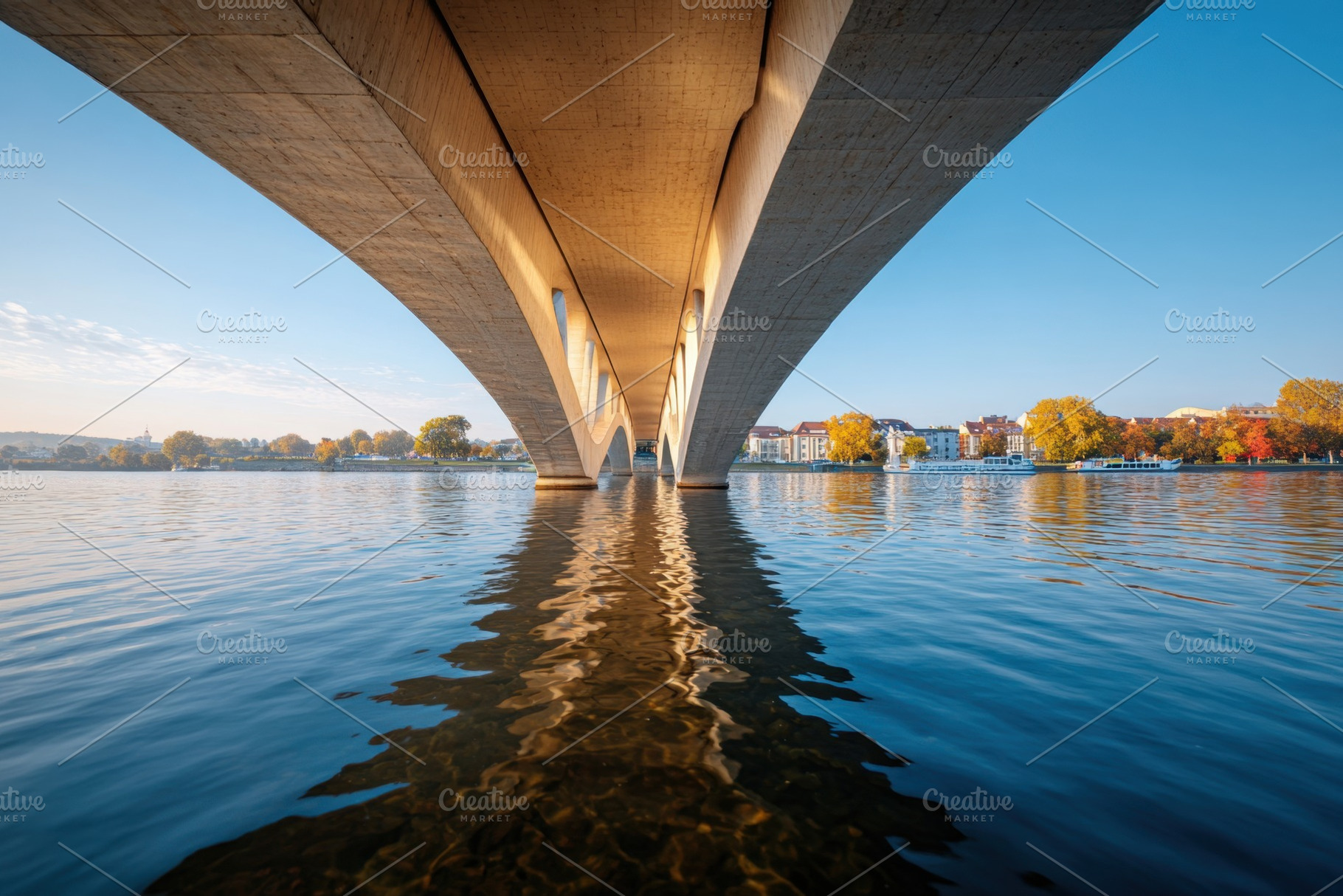 Underneath a modern bridge with autumn reflections, an Architecture Photo by AlyaAnd