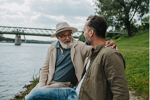 Father and adult son sharing a, a Person Photo by HalfPoint