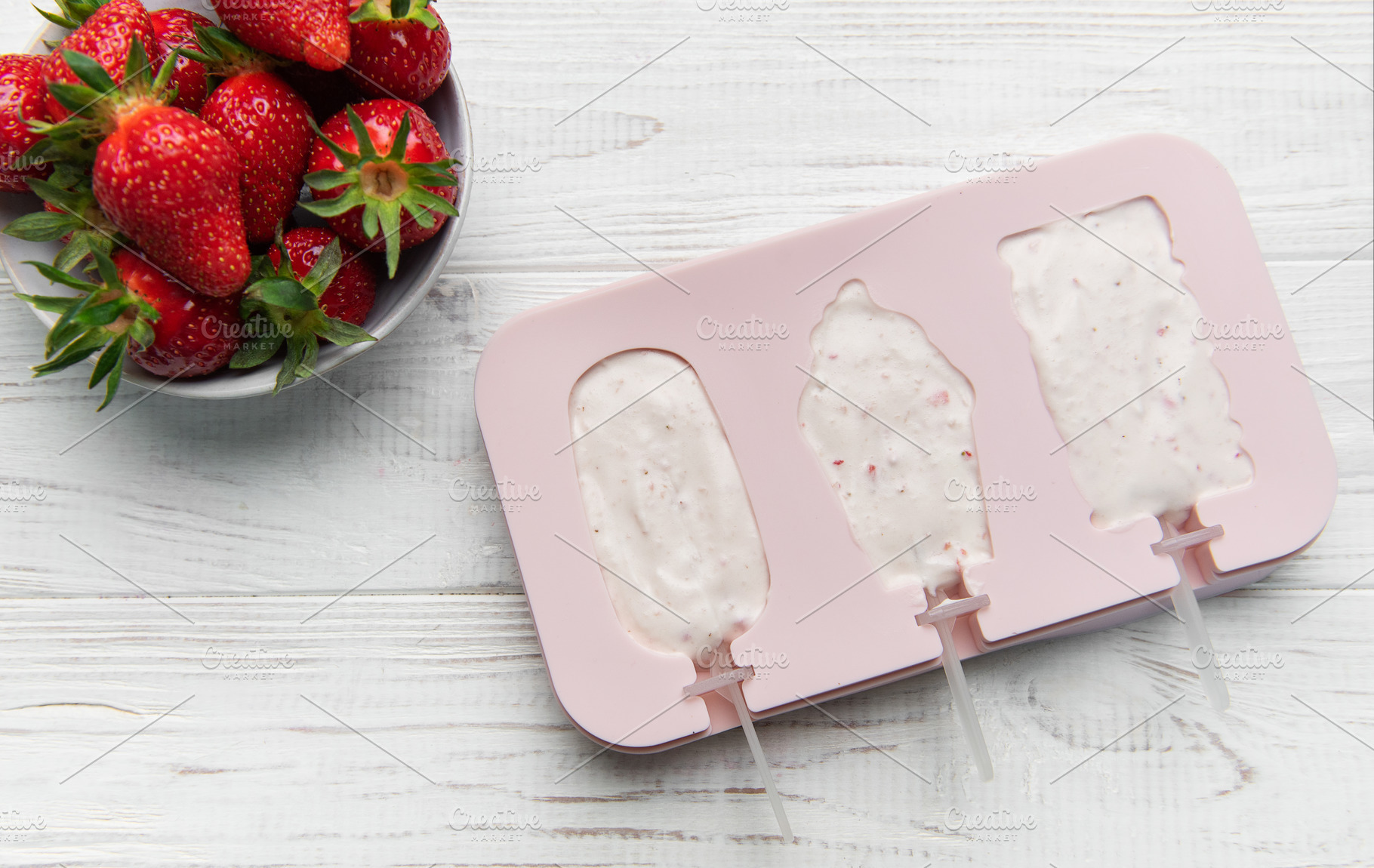 Preparing homemade strawberry yogurt popsicles on wooden backgro, a Food & Drink Photo by Olena Rudo