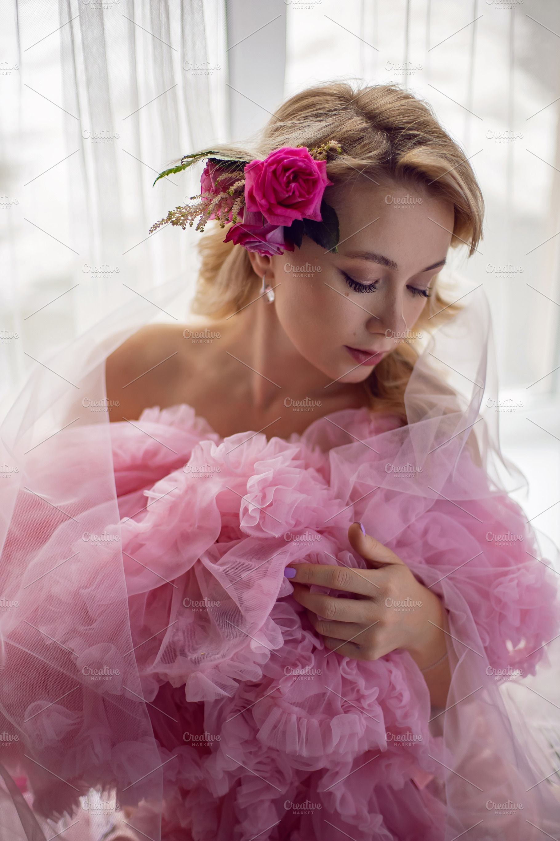 portrait of a fashionable blonde woman in a pink dress and rose flower in her h, a Person Photo by SaulichPhoto
