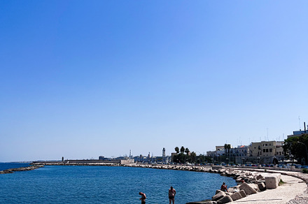 Sunny coastal view with clear blue skies and rocky shoreline. Bari, Italy., a Photo by AS photostudio