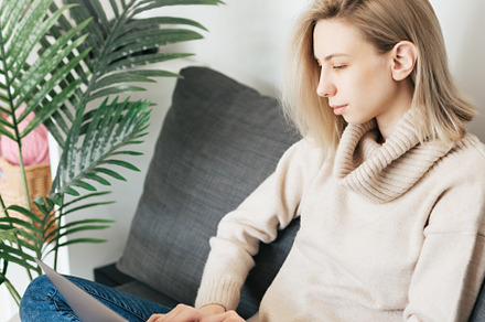 Young woman working on laptop in  home, a Person Photo by Olena Rudo