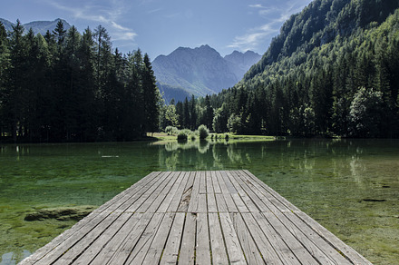 Wooden pier on the lake featuring mountains, sky, and forest, a Nature Photo by PremiumCoding