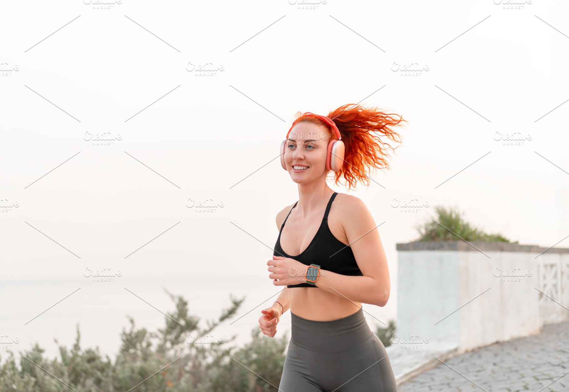 Happy sporty jogger woman jogging against seascape against clear sky, a Person Photo by andreonegin market