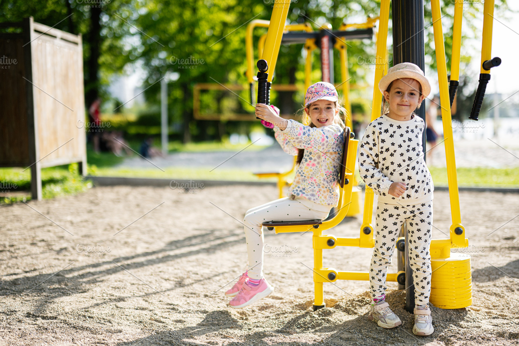 Two children playing on outdoor gym equipment in a sunny park setting, a Person Photo by AS photostudio