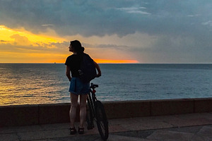 Woman watching the sunset over the ocean in peaceful silence, a Person Photo by DanFLCreativo