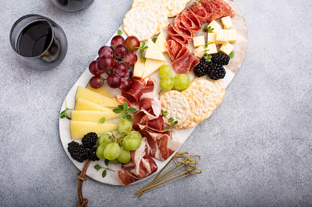 Cheese or snack board with meat and fruit, a Food & Drink Photo by farwasser