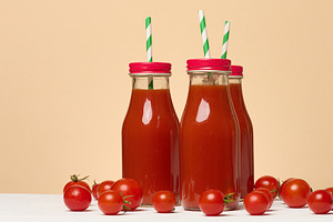 Tomato juice in a glass bottle and fresh cherry tomatoes on the, a Food & Drink Photo by ndanko
