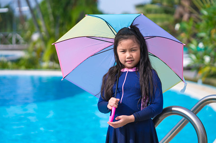 little girl smiling near in swimming pool and holding colourful, a Sports & Recreation Photo by Casanowe-studio