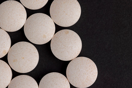 White and yellow medical medicines on a black background, a Background Photo by MyPhotos