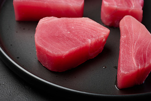 Raw tuna pieces on a black round plate, a Food & Drink Photo by ndanko