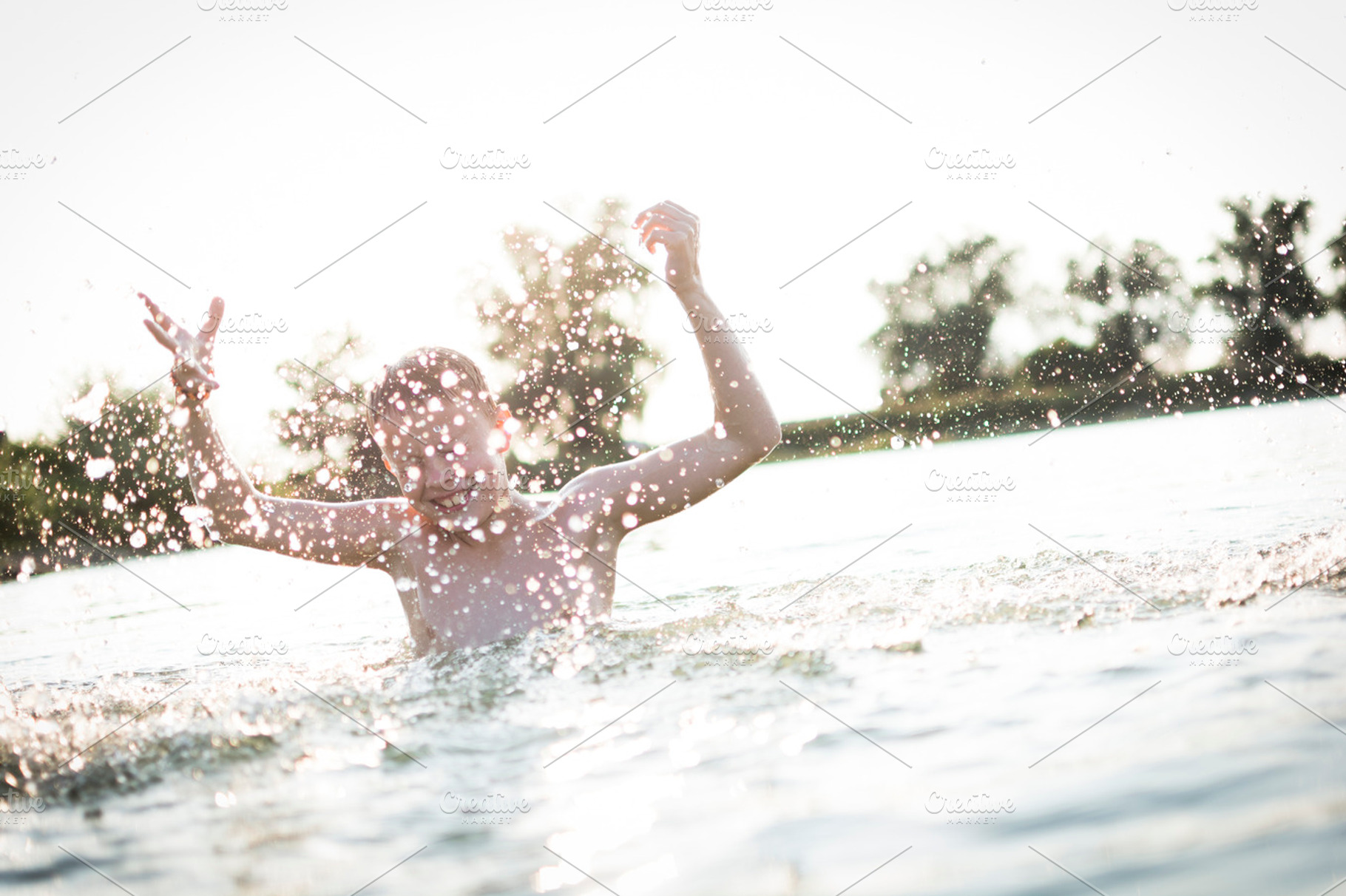 Boy having fun in a lake containing outdoor, wet, and fun, a Person Photo by Twin Design