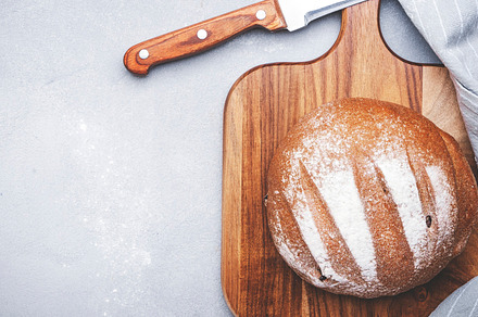 Rye sourdough bread, sliced pieces on wooden cutting board, brea, a Food & Drink Photo by 5PH