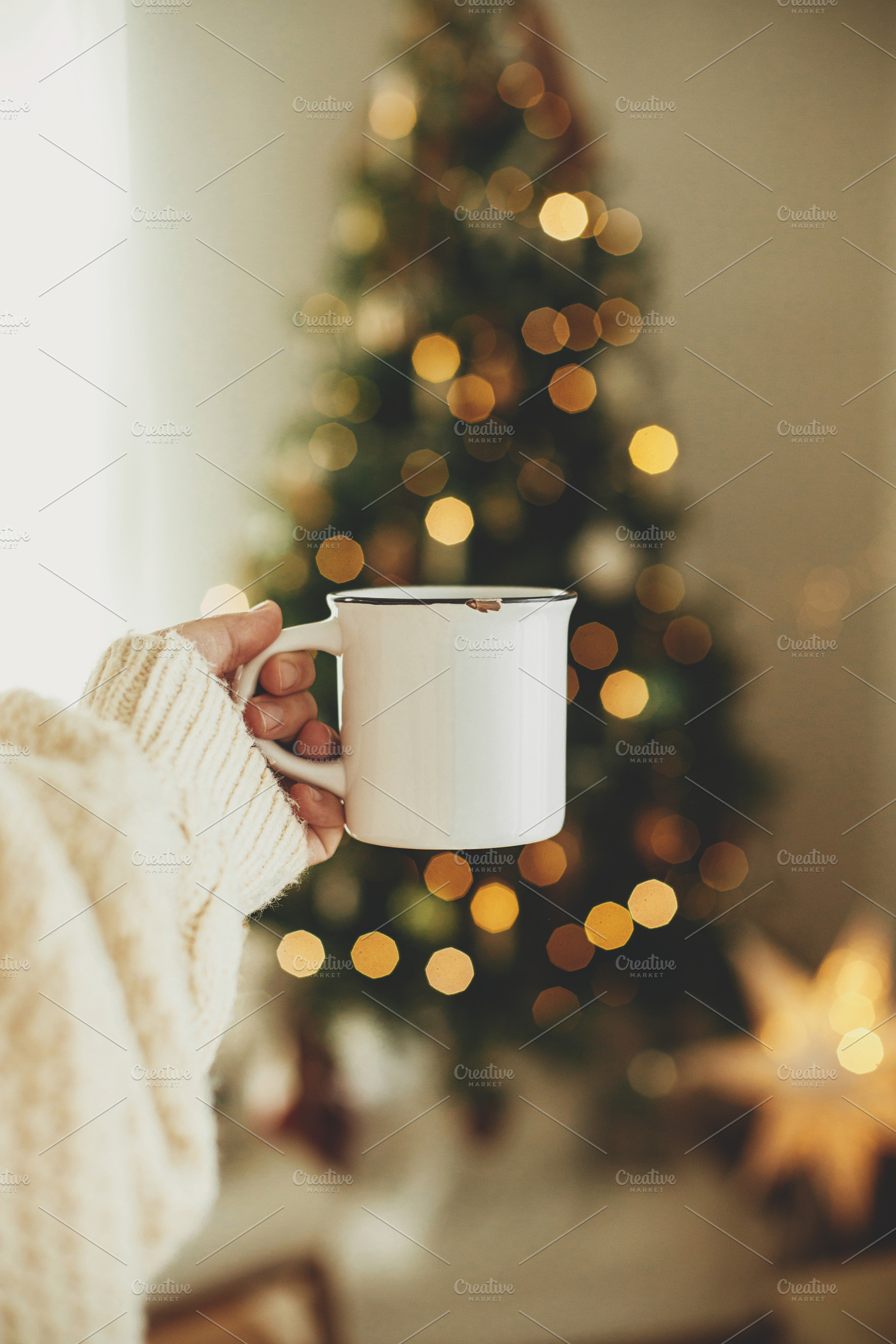 Hand holding stylish white cup against stylish festive christmas, a Holiday Photo by Sonjachni