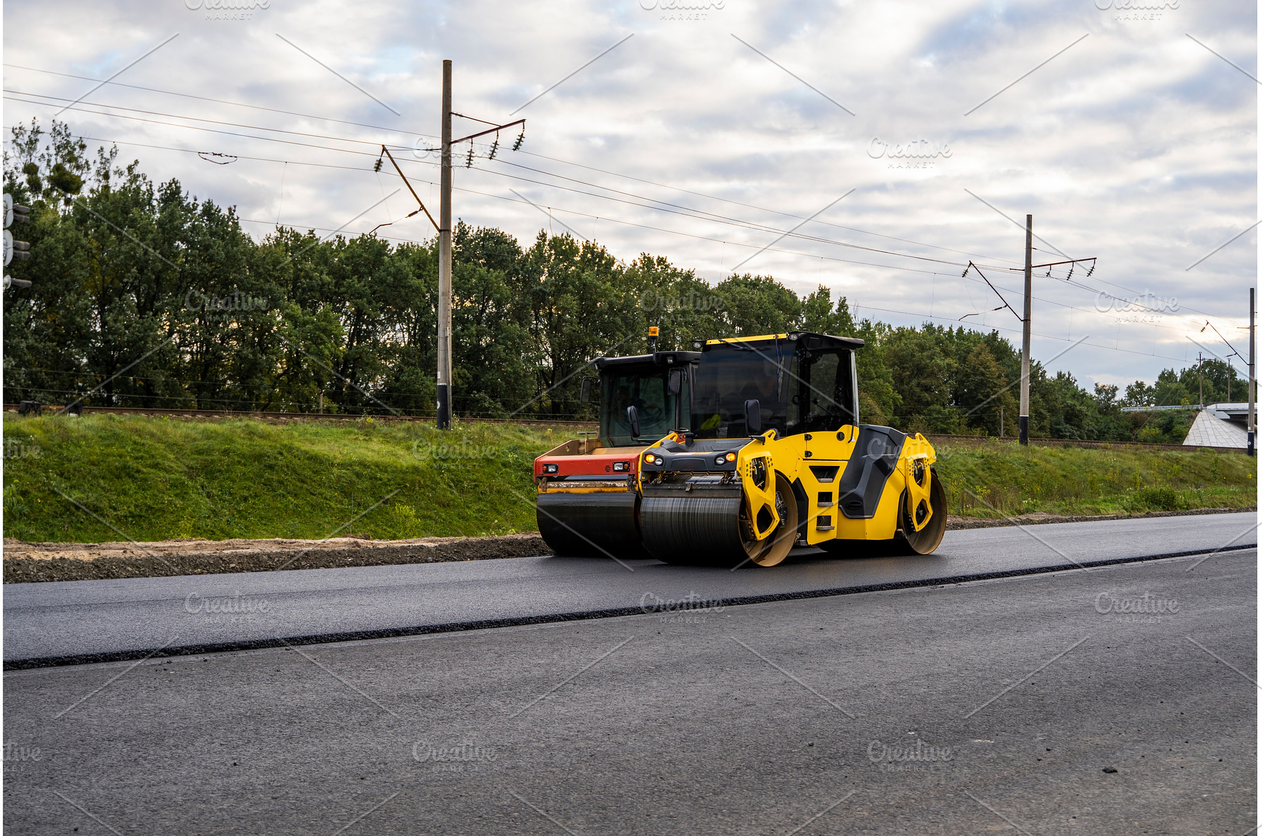 Road roller working on fresh asphalt, an Industrial Photo by volodymyrshtun13795