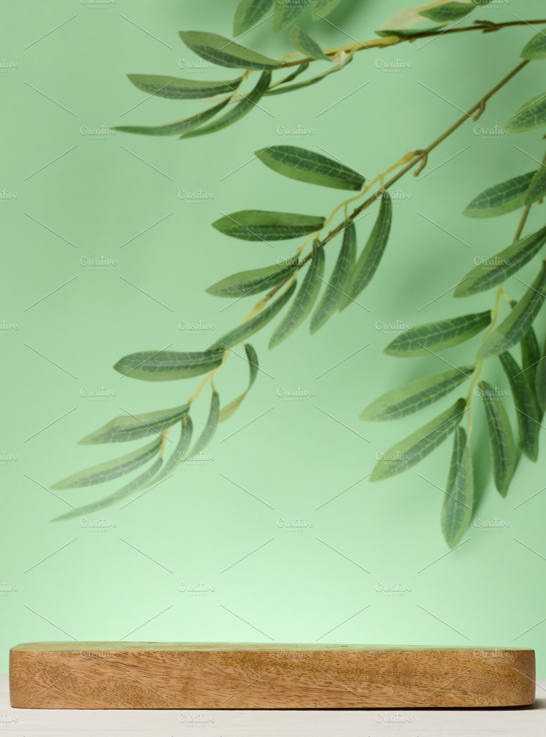 Empty wooden board on green background, stage for display and ad, a Food & Drink Photo by ndanko