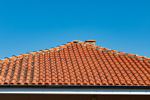 Close-up of a terracotta tiled roof under a clear blue sky, highlighting archit, an Architecture Photo by Ales Munt