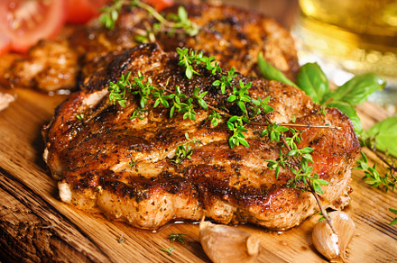Fried pork steak on a wooden board, a Food & Drink Photo by Apolonia