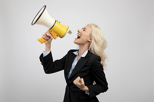 Breaking news. Businesswoman shouting into megaphone, advertising something, an, a Photo by Prostock-Studio