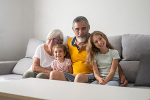Happy multigenerational family sitting together on the sofa, a Person Photo by etorres69