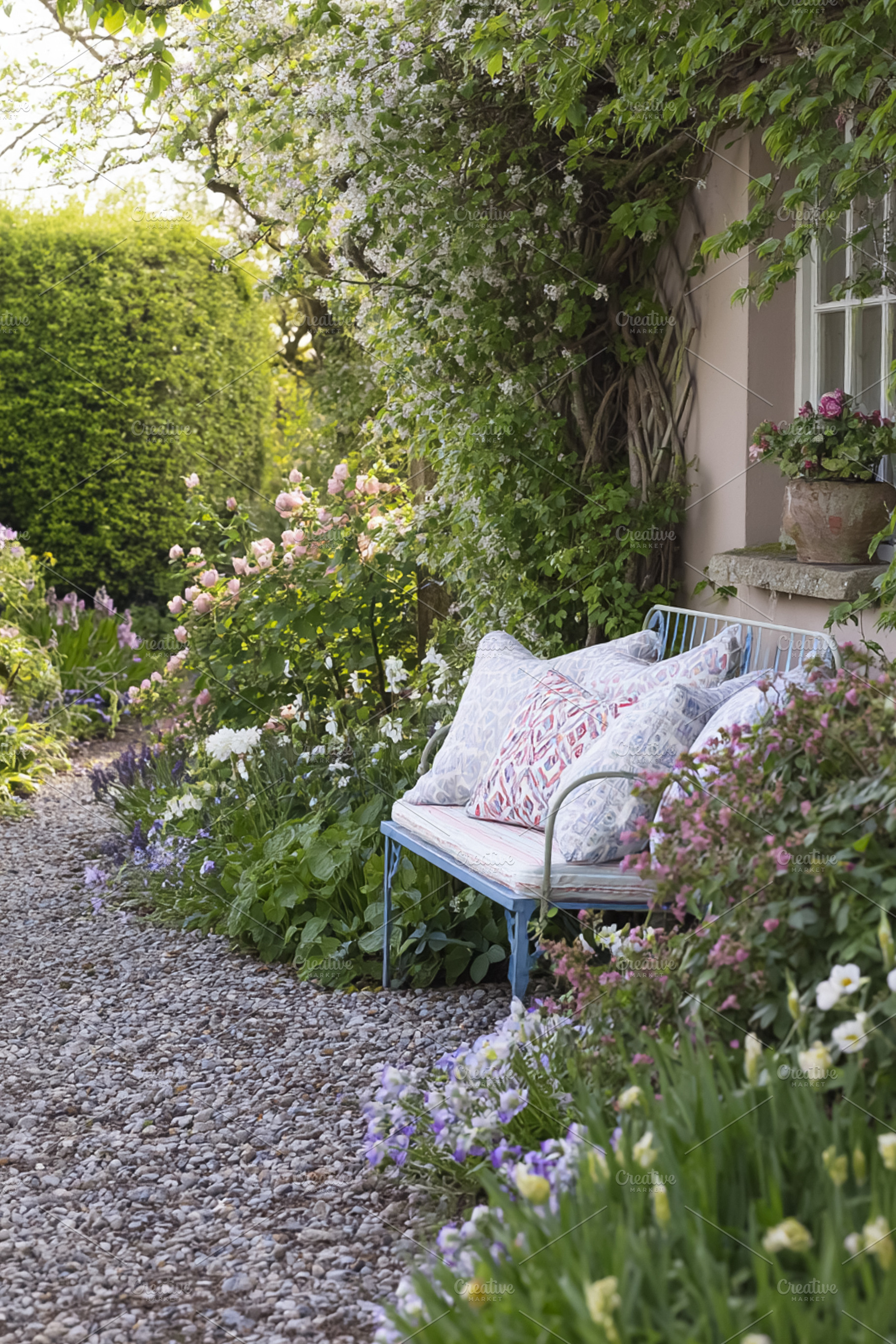 Tranquil spring garden path with a blue metal bench and decorati, a Photo by Studio ANNA