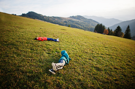 Brothers lying in the grass with a gorgeous mountain range in th, a Person Photo by AS photostudio