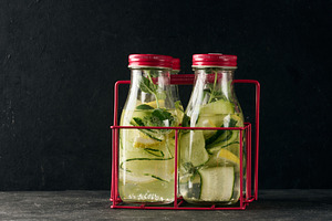 Gass bottles with red lids filled with detox water containing cu, a Food & Drink Photo by ndanko