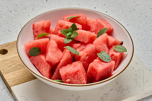 Ripe watermelon slices with mint leaves in a white round plate o, a Food & Drink Photo by ndanko