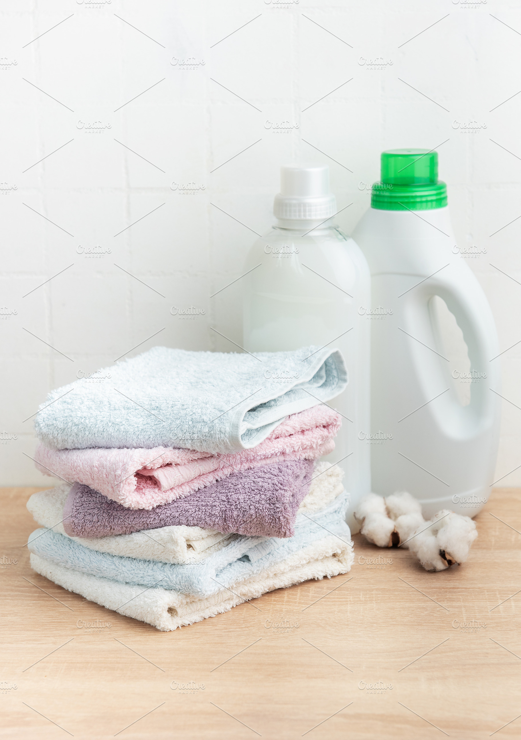 Stack of soft clean towels with laundry detergents, an Industrial Photo by Olena Rudo