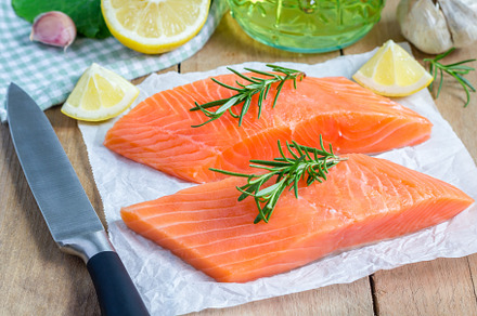 Fresh raw salmon fillet with rosemary and lemon, a Food & Drink Photo by iuliia_n