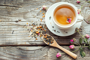 White cup of aromatic tea on wooden table, a Food & Drink Photo by AlyaAnd