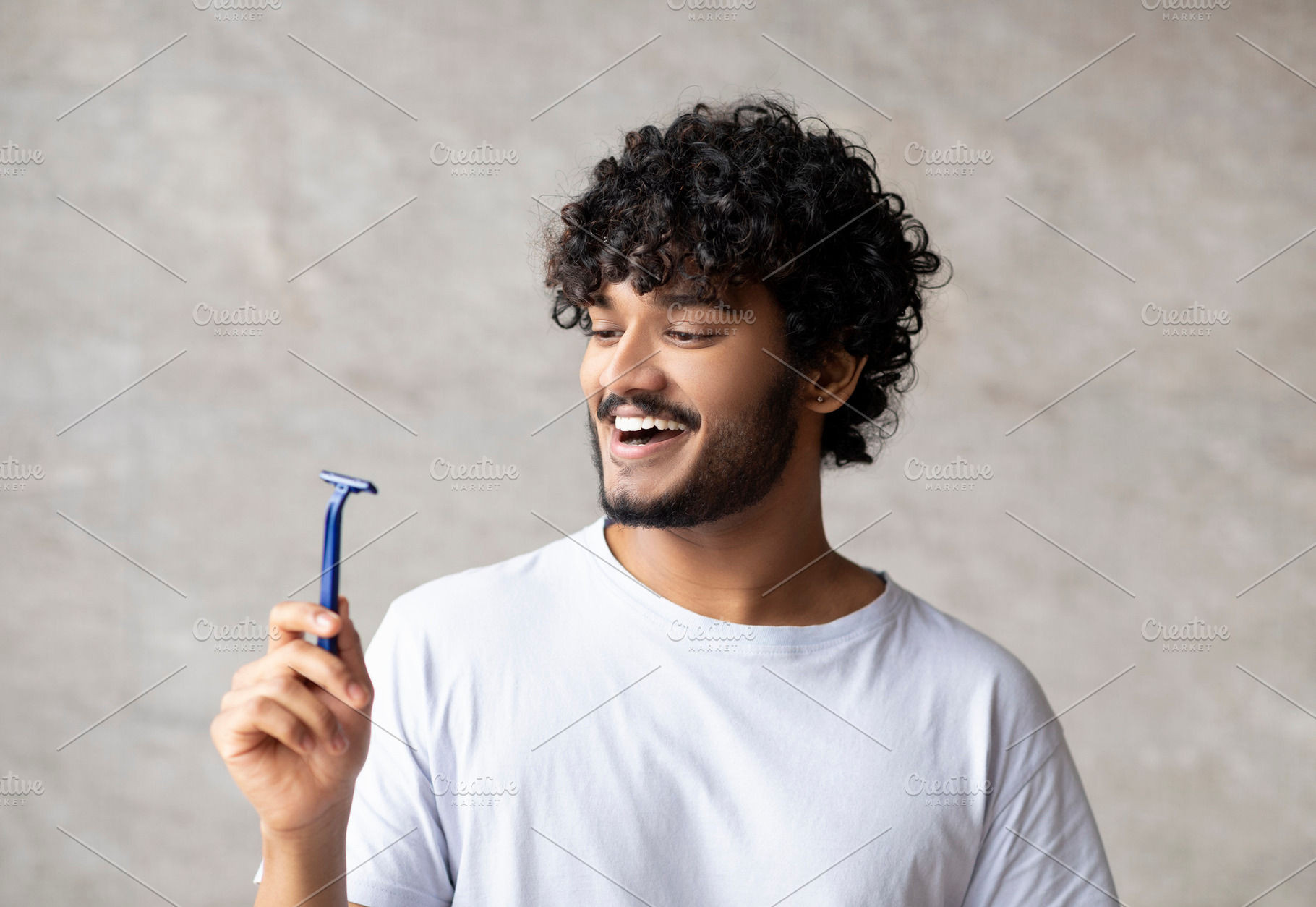 Body care concept. Happy indian man holding razor and smiling, standing in bath, a Person Photo by Prostock-Studio