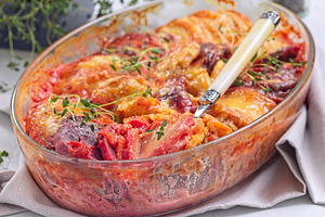 Au gratin with sweet potato, parsnips, beet root and melted cheese, in glass di, a Food & Drink Photo by iuliia_n