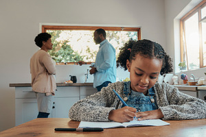 Child writing homework at kitchen table, a Person Photo by DanFLCreativo