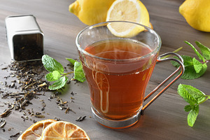 Black tea with lemon and mint on dark wooden table, a Food & Drink Photo by Davizro's Market