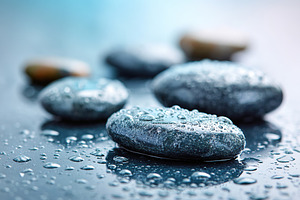 Wet stones glisten with droplets in a calming, serene setting after a gentle ra, a Photo by AlyaAnd