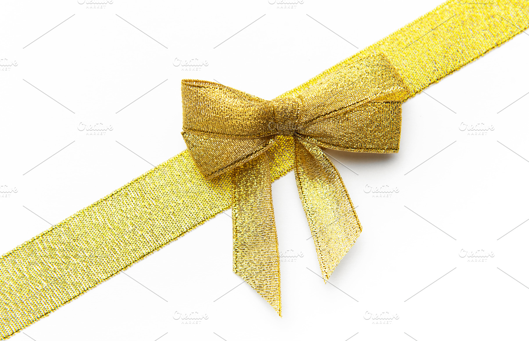 Golden glittery ribbon bow decorating a festive gift, a Photo by Olena Rudo