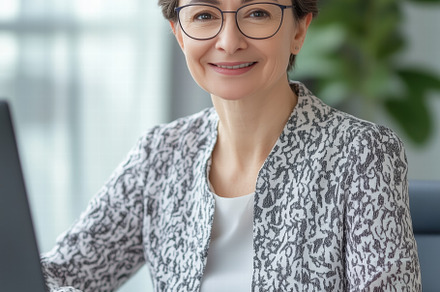 A professional woman accountant with short brown hair and glasses smiles at the, a Person Photo by Textures & Backgrounds