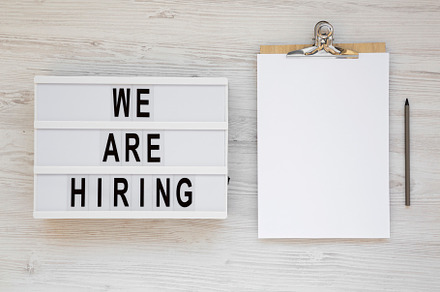 'We are hiring' words on a lightbox, clipboard with blank sheet, a Business Photo by LiudmylaChuhunova