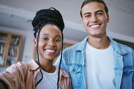 Selfie, friends and portrait smile at university campus and happy for learning, education and friendship in a library. Young Man and woman students at college smile for scholarship and knowledge, a Photo by Peopleimages.com
