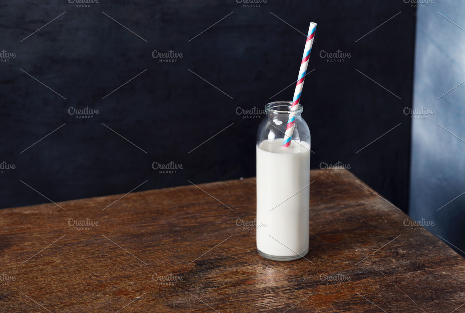 Glass bottle of milk with straw, a Food & Drink Photo by KucherPhoto