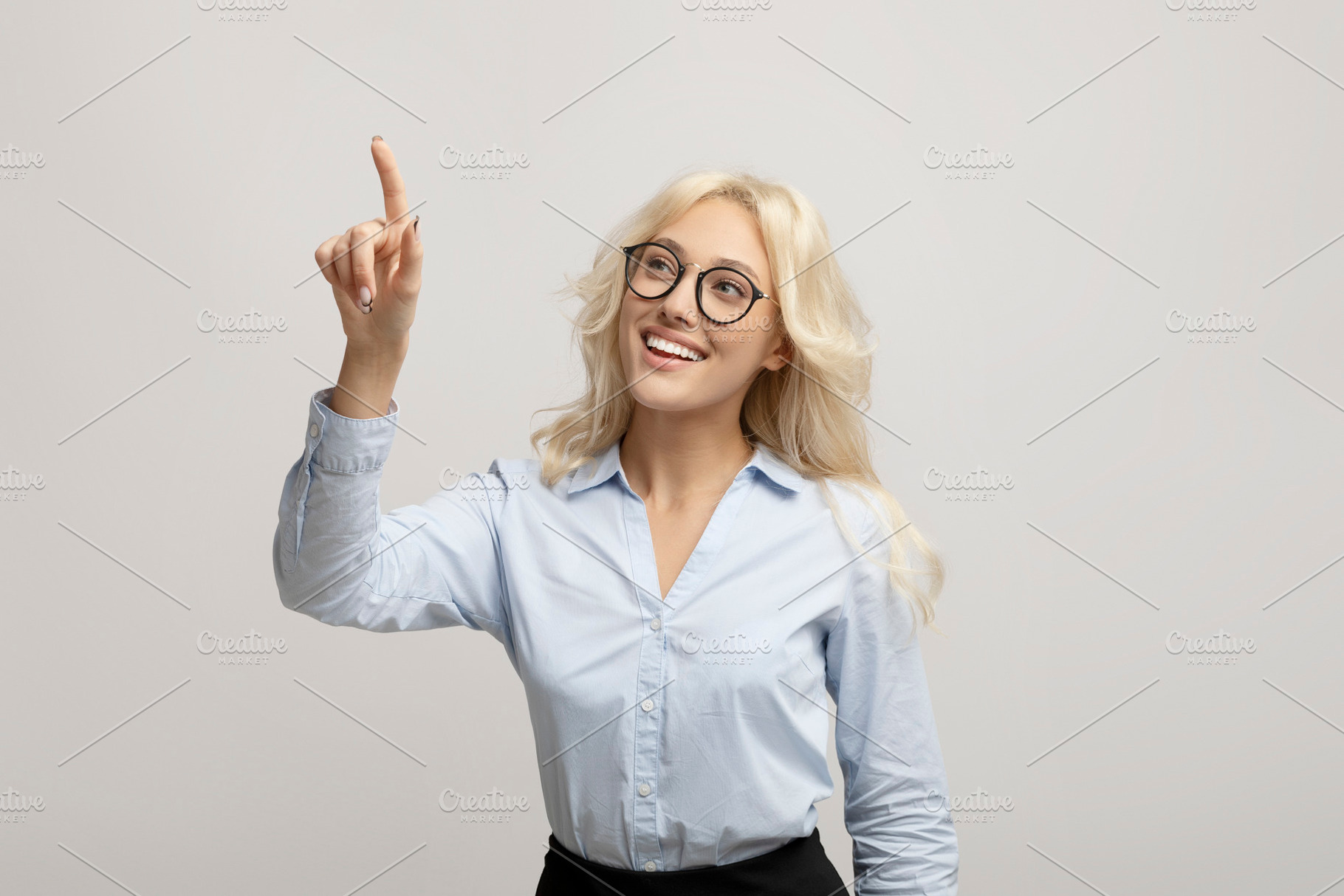Happy female entrepreneur pushing button on virtual screen over light grey stud, a Photo by Prostock-Studio
