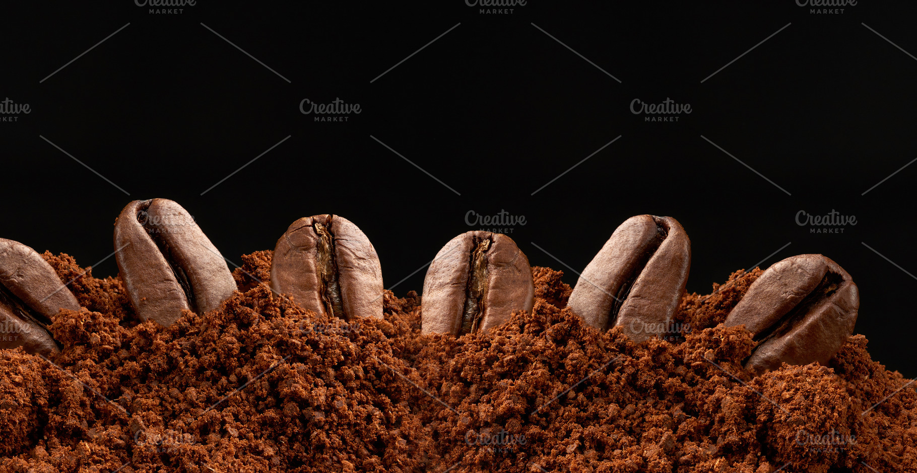 Roasted coffee beans in ground coffee on a black background, a Food & Drink Photo by ndanko