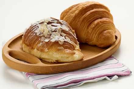 Baked crisp croissant on wooden board, white table. Breakfast, a Food & Drink Photo by ndanko