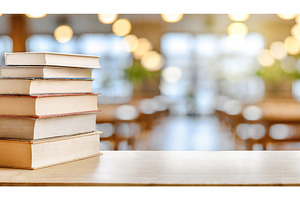 Stack of books on a desk in a softly, a School & Education Photo by Igor Tichonow