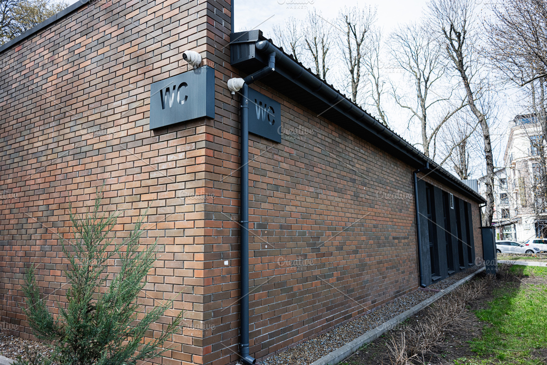 Modern public restroom building with clear signage in a natural urban setting, a Photo by AS photostudio