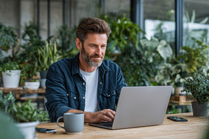 Man working on laptop surrounded by, a Photo by Pixeness Studio