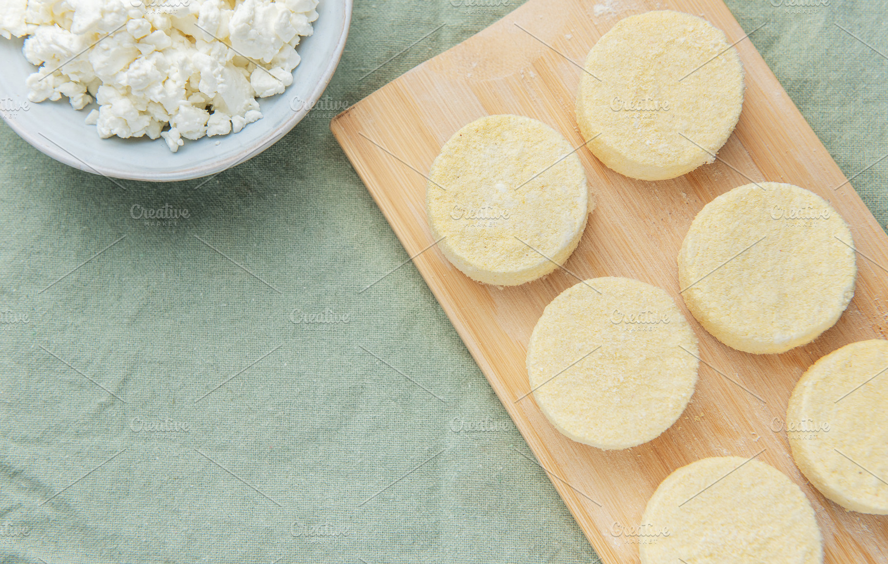 Preparing syrniki cottage cheese pancakes on cutting board, a Food & Drink Photo by Olena Rudo