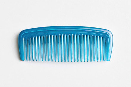Blue plastic comb with fine teeth placed on a plain background for styling and, a Beauty & Fashion Photo by AlyaAnd